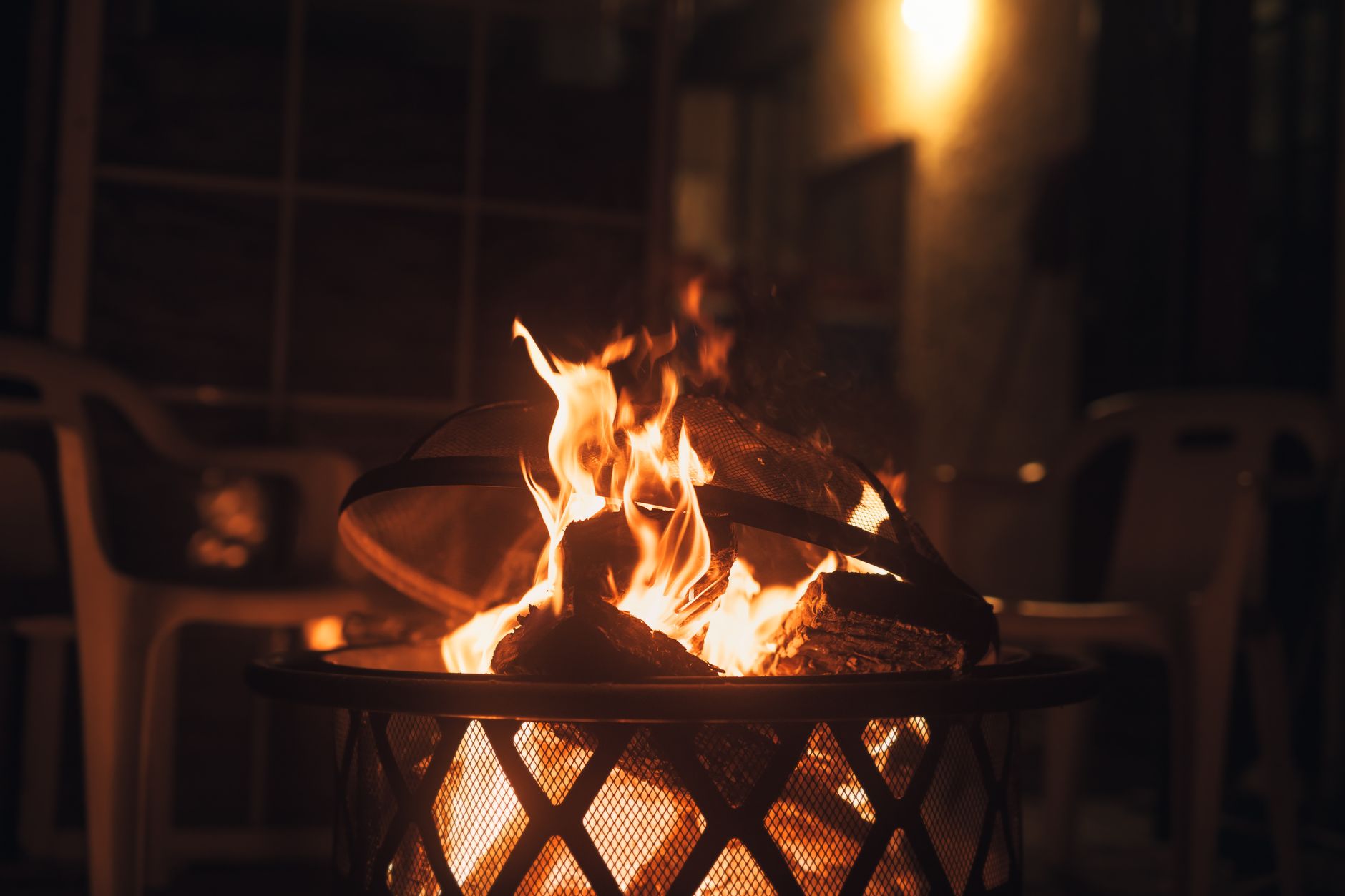 Fire pit burning in a basket on a patio in the evening